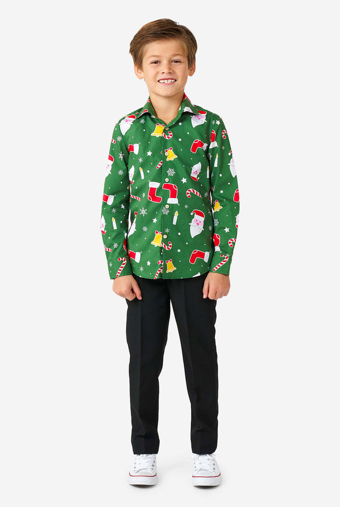 Kind, das ein grünes Weihnachtshemd mit Weihnachtsikonen trägt