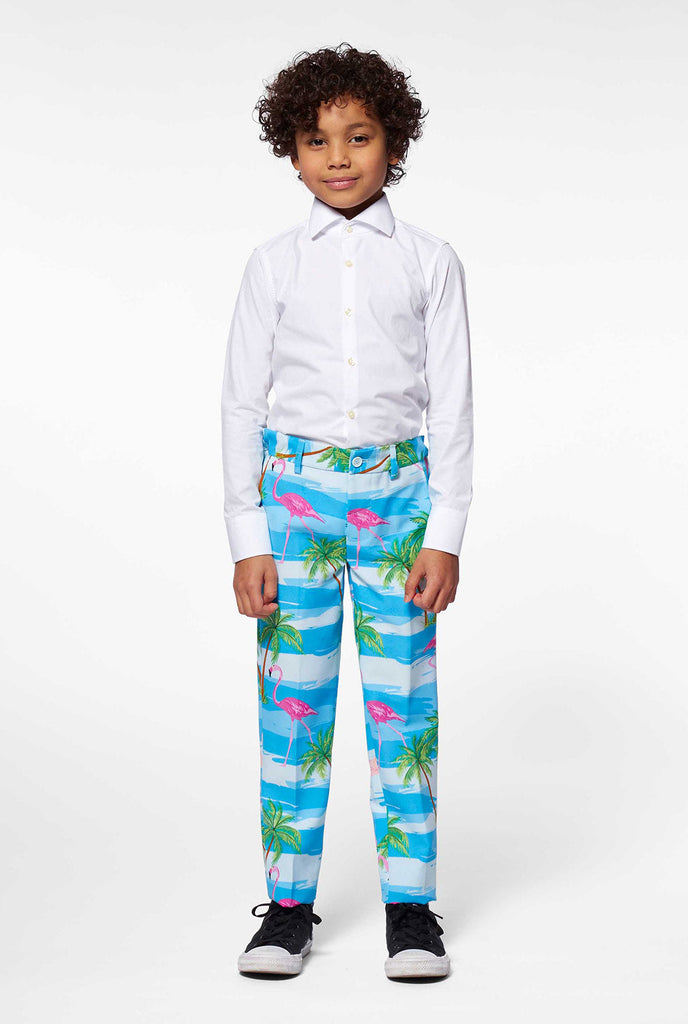 Kind trägt hellblaue tropische Hosen Teil des Flamingo -Druckanzugs für Jungen, die von Jungen getragen werden