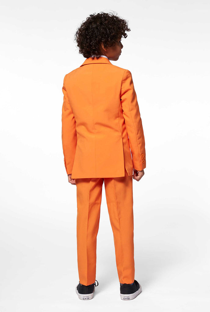 Feste farbige orangefarbene Jungenanzug von Jungen von hinten getragen