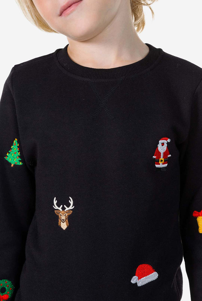 Kind trägt einen schwarzen Weihnachtspullover mit Weihnachtselikonen, Nahaufnahme