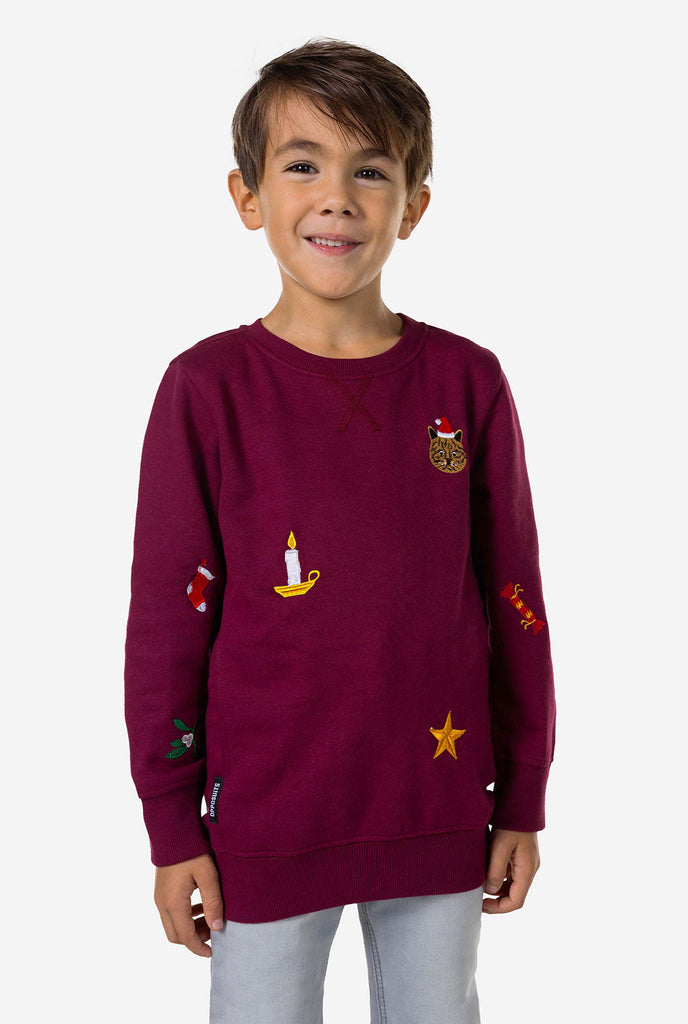 Kind mit burgunderroten roten Weihnachtspullover mit Weihnachtselikonen