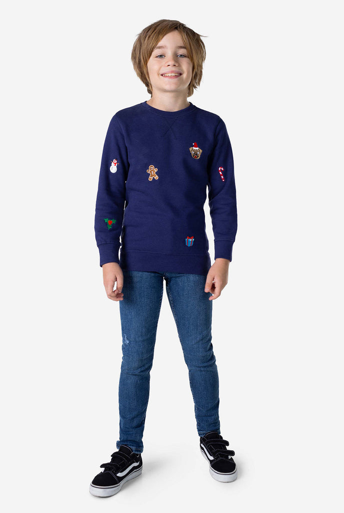 Kind trägt blauen Weihnachtspullover mit Weihnachtselikonen
