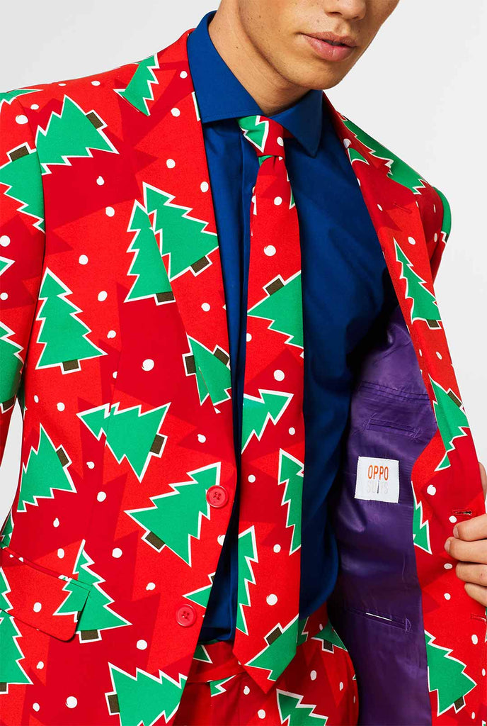 Roter Weihnachtsanzug mit Kiefernabdruck, der vom Mann getragen wird, der in der Jacke zeigt