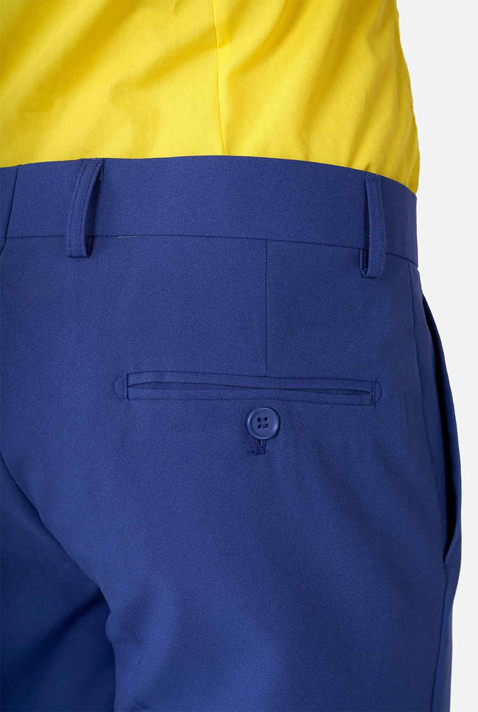 Mann, der blaue Hosen Teil des Herrenanzugs im Retro -Stil von Memphis Group, Nahaufnahme Hose