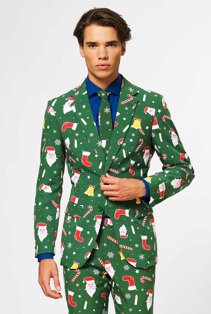 Mann, der grünen Weihnachtsanzug und ein blaues Hemd trägt