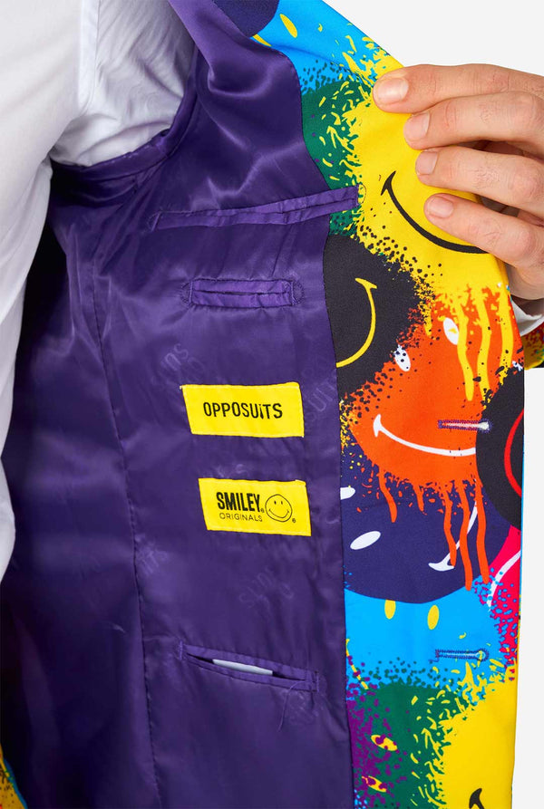 Mann, der einen farbenfrohen Männeranzug mit Smiley -Druck trägt, Blick im Innen