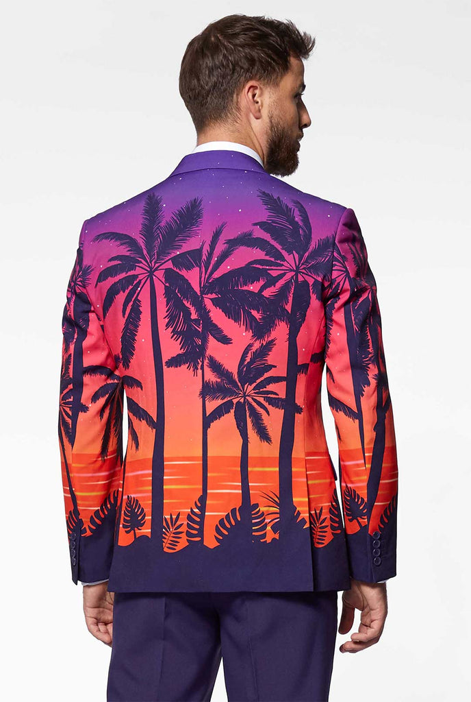 Mann, der suave Sonnenuntergang Hawaiianer Anzug trägt, Blick von hinten
