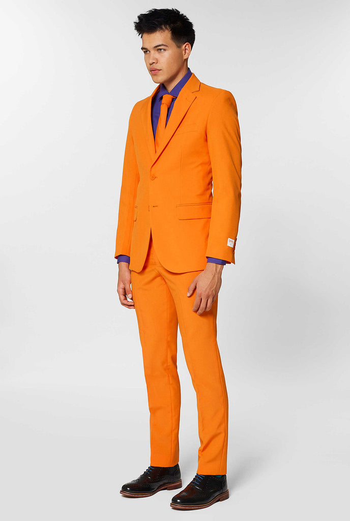 Mann, der orangefarbenen Herrenanzug mit lila Hemd trägt
