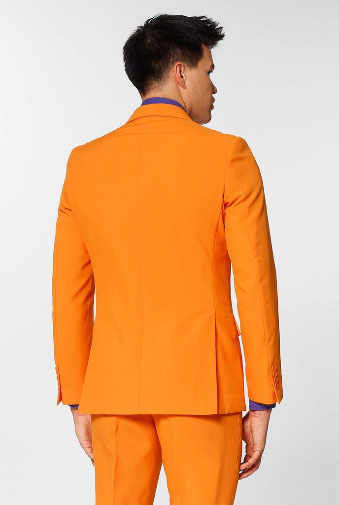 Mann, der orangefarbenen Herrenanzug mit lila Hemd trägt, Blick von hinten