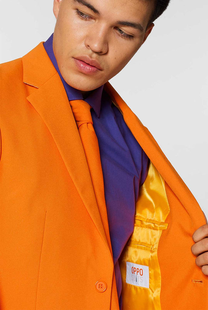 Mann, der orangefarbenen Herrenanzug mit lila Hemd trägt, Nahaufnahme