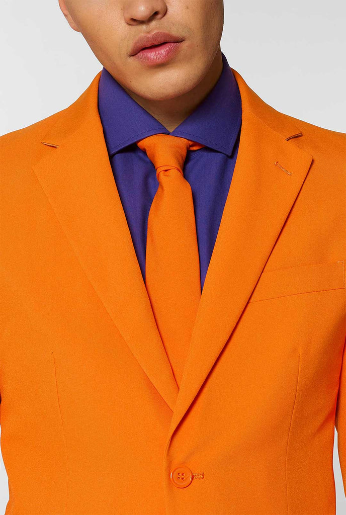 Mann, der orangefarbenen Herrenanzug mit lila Hemd trägt, Nahaufnahme