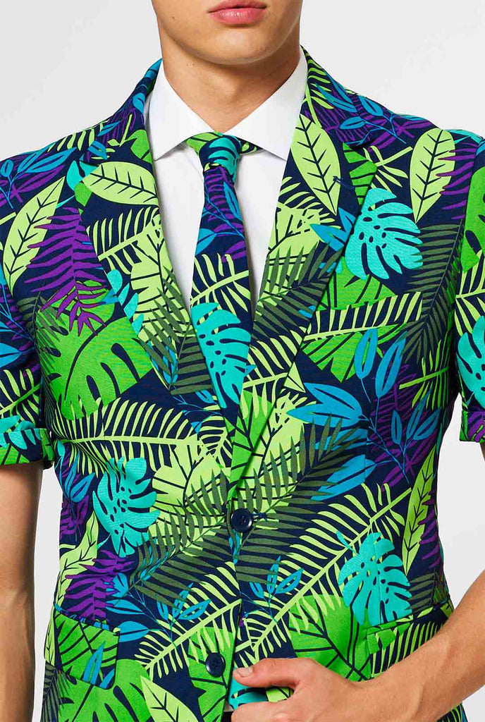 Mann, der grünen Sommeranzug mit Dschungelblattdruck trägt, Nahaufnahme Jacke und Krawatte