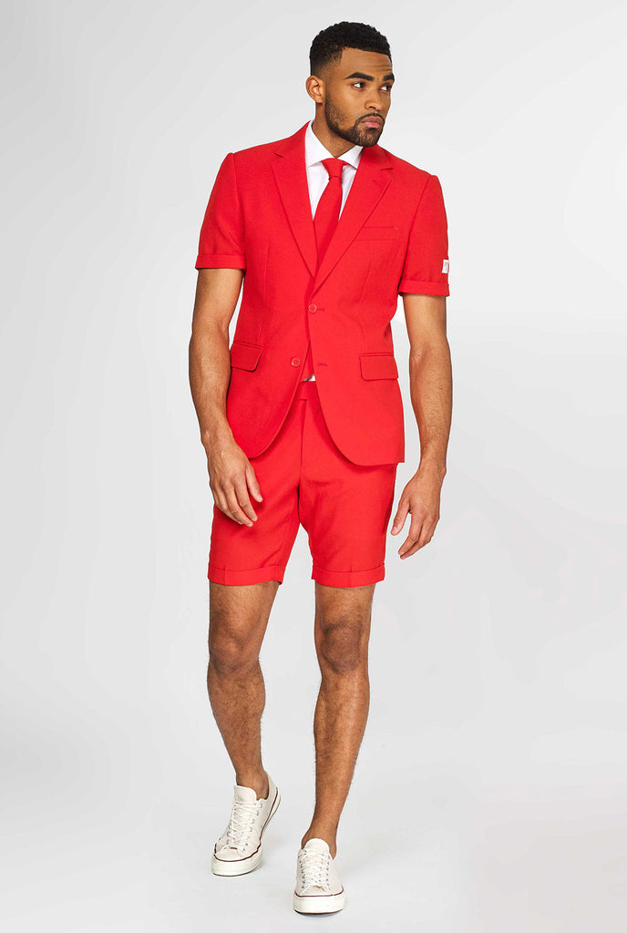 Mann, der einen roten Sommeranzug trägt, bestehend aus Shorts, Jacke und Krawatte