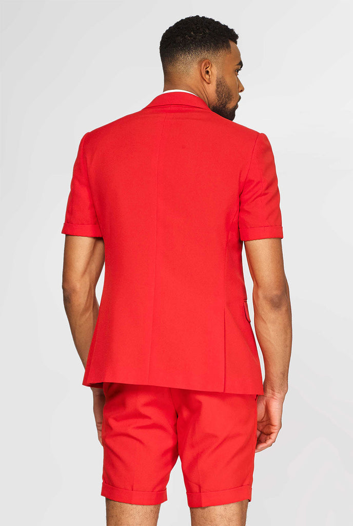 Mann, der roten Sommeranzug trägt, bestehend aus Shorts, Jacke und Krawatte, Blick von hinten