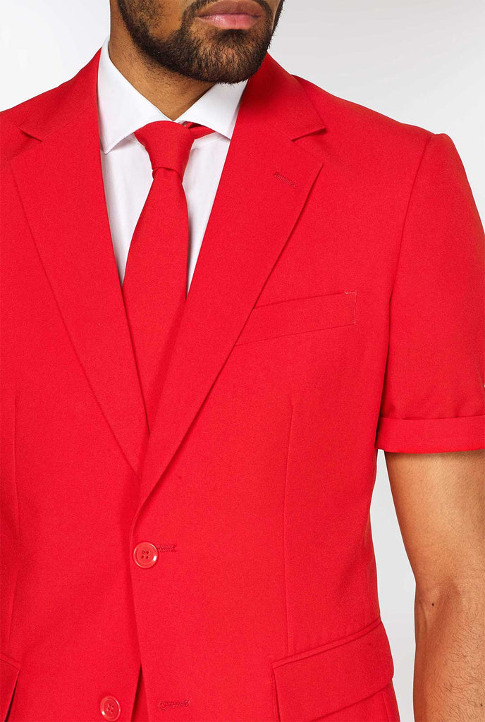 Mann, der einen roten Sommeranzug trägt, bestehend aus Shorts, Jacke und Krawatte, Nahaufnahme Jacke und Krawatte