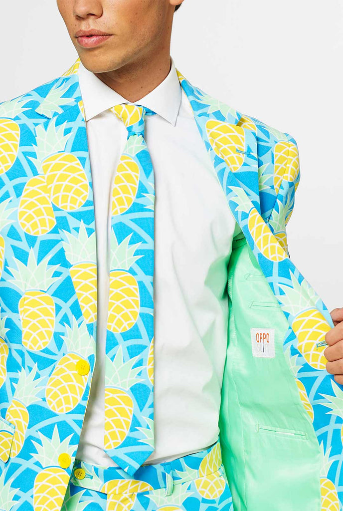 Mann, der einen blauen Sommeranzug mit Ananasdruck trägt, Nahaufnahme Jacke und Krawatte
