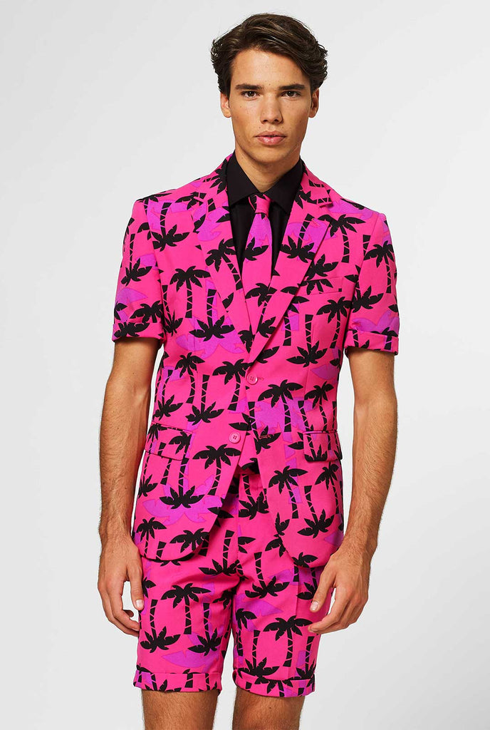 Mann, der rosa Sommeranzug mit Palmdruck trägt