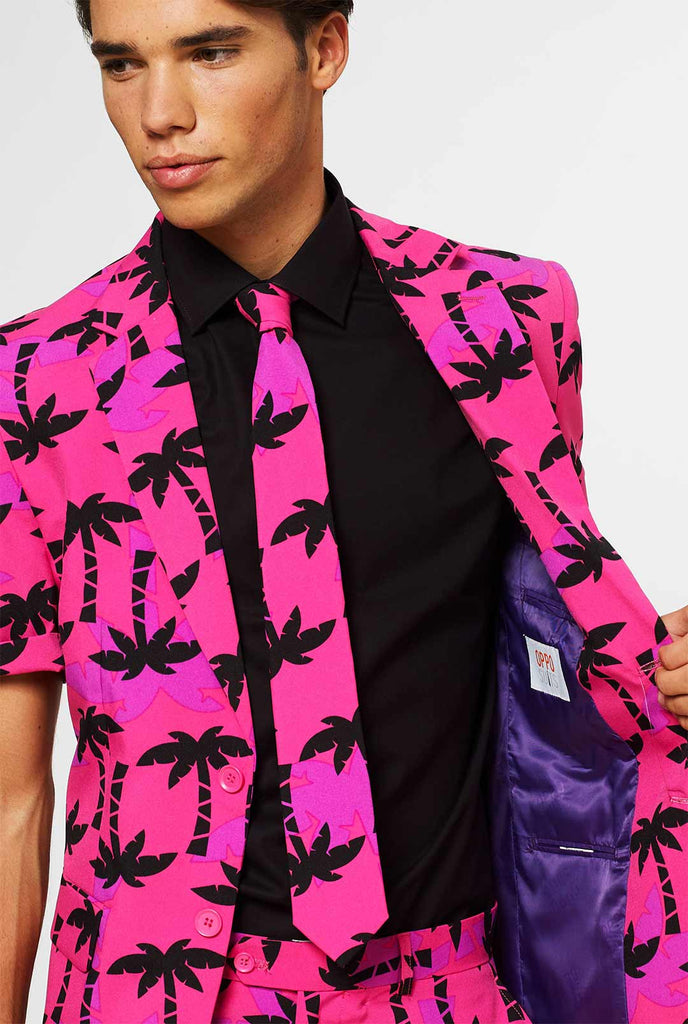 Mann, der rosa Sommeranzug mit Palmdruck trägt, Nahaufnahme Jacke und Krawatte
