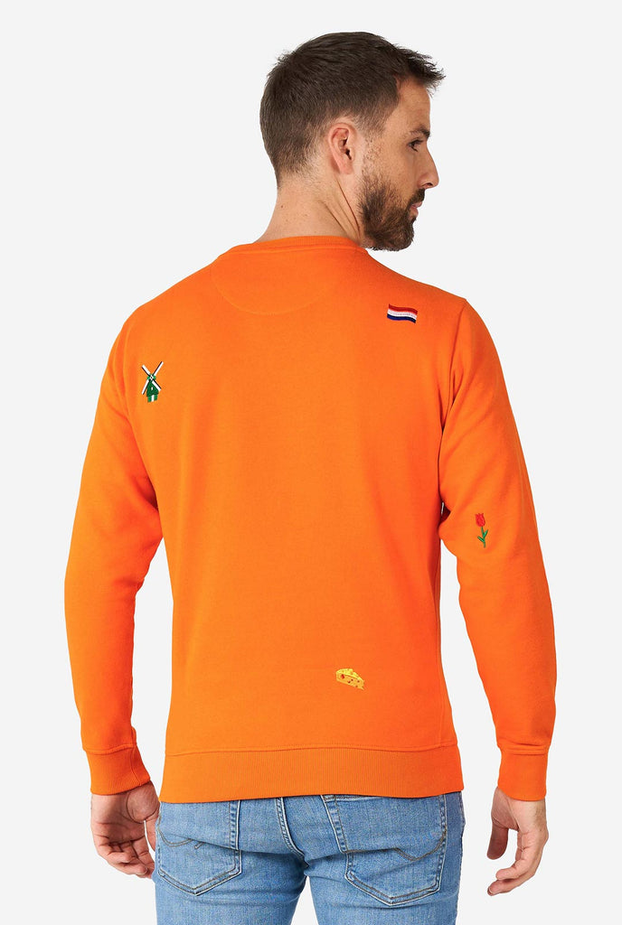 Mann, der einen orangefarbenen Pullover mit niederländischen Ikonen trägt, Blick von hinten