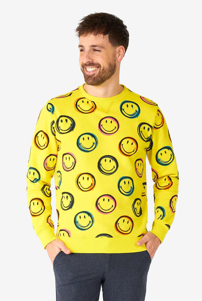 Mann, der gelben Männerpullover mit Smiley -Druck trägt
