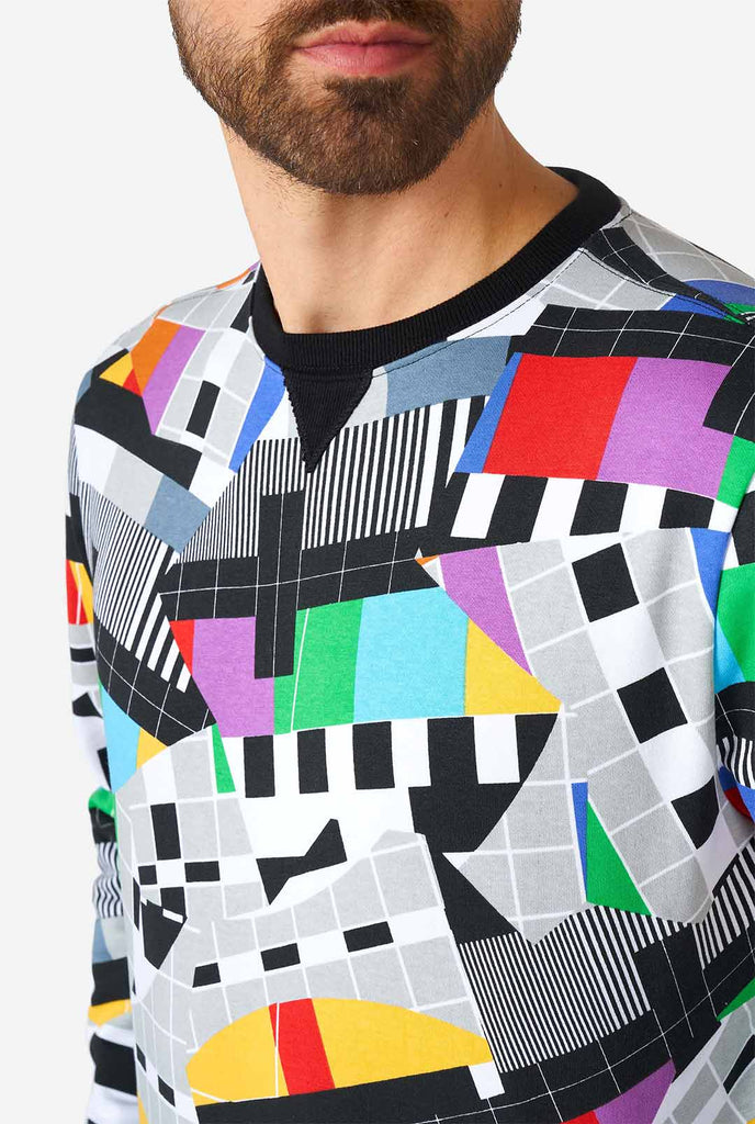 Mann, der Retro-TV-Tests-Multi-Farben-Pullover trägt, Nahaufnahme