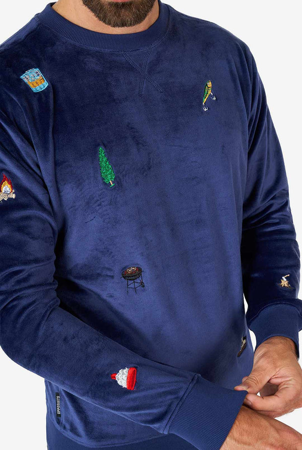 Mann, der samtig blaue Weihnachtspullover mit Weihnachtselikonen trägt, Nahaufnahme