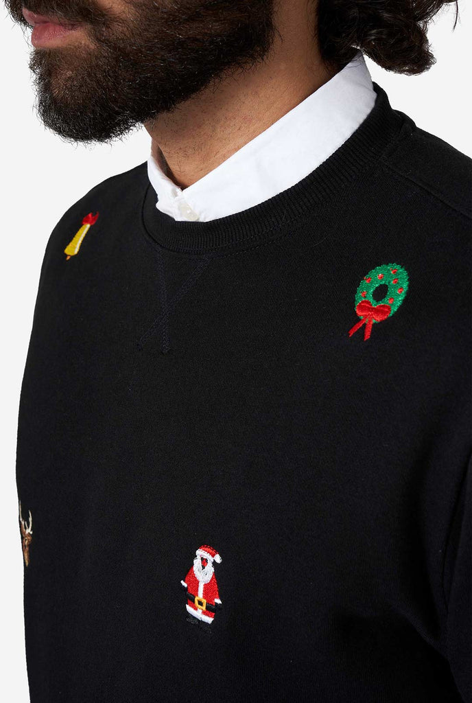 Mann trägt einen schwarzen Weihnachtspullover mit Weihnachtsikonen, Nahaufnahme