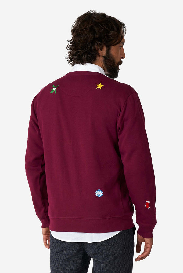 Mann, der burgunderrote rote Weihnachtspullover mit Weihnachtselikonen trägt, Blick von hinten