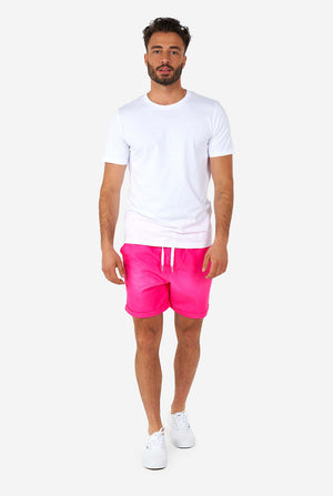 Mann, der bunte Sommershorts und ein weißes Hemd trägt