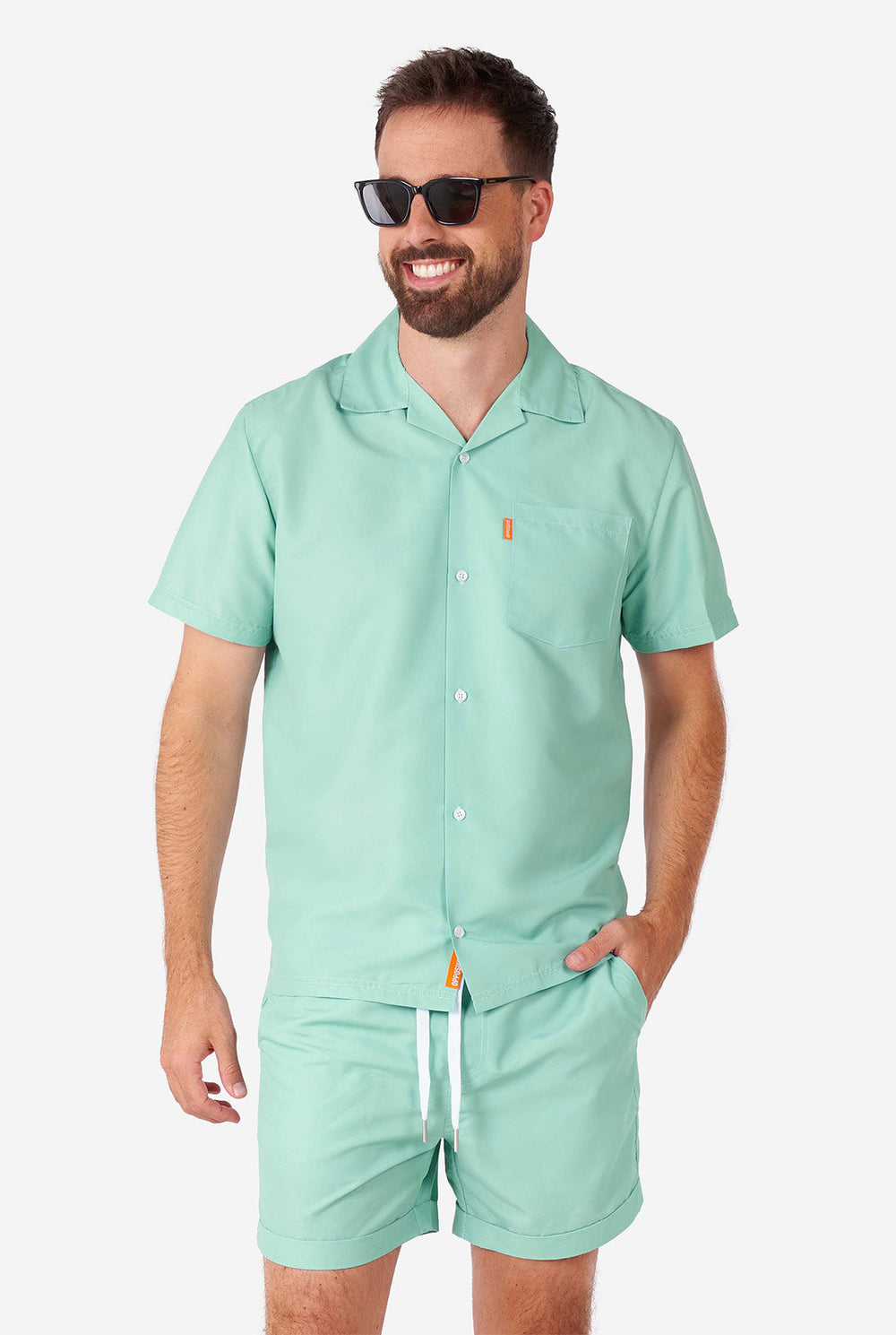 Mann, der ein grünes Sommerset trägt, bestehend aus kurzem Ärmelhemd und Shorts.