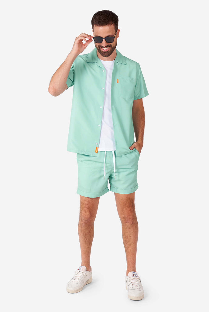 Mann, der ein grünes Sommerset trägt, bestehend aus kurzem Ärmelhemd und Shorts.