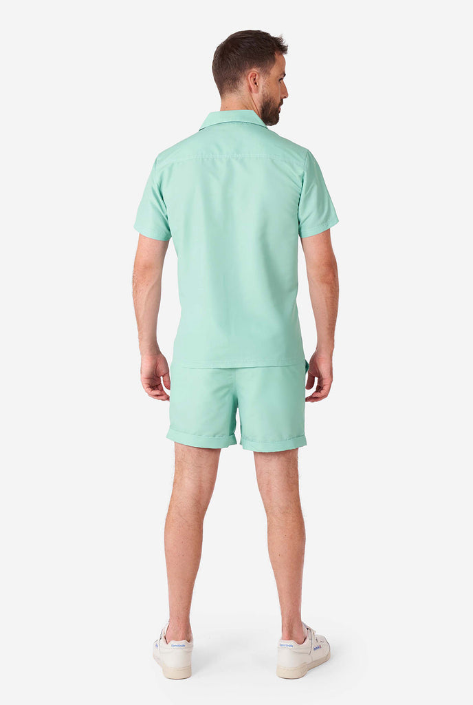 Mann, der ein grünes Sommerset trägt, bestehend aus kurzem Ärmelhemd und Shorts., Blick von hinten
