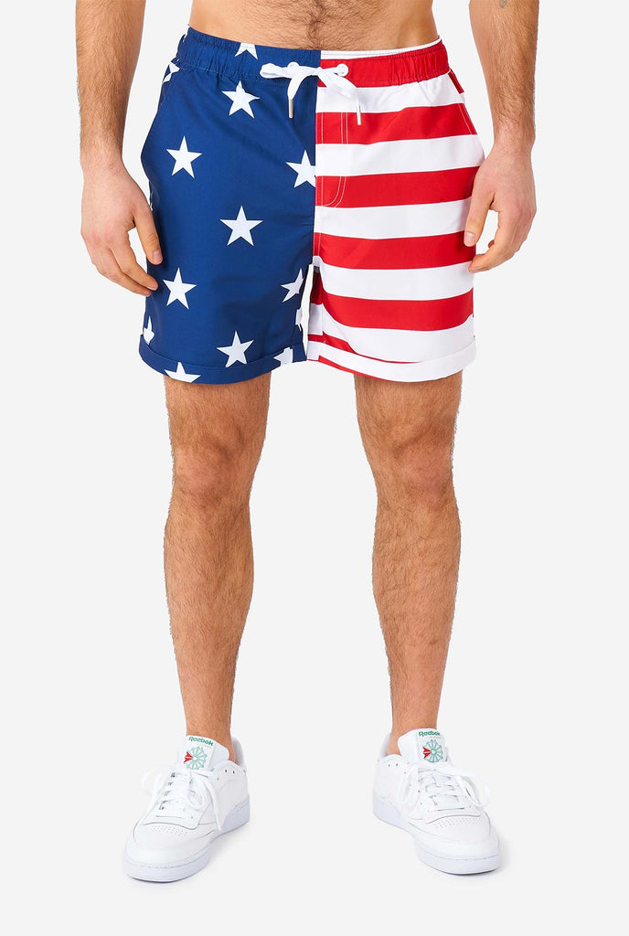 Mann, der Sommer -Outfit trägt, bestehend aus Hemd und Shorts, mit US -amerikanischen Flaggendruck, Shorts in der Nähe