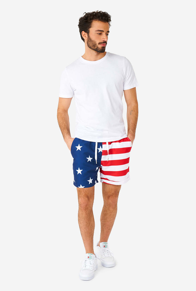 Mann trägt Sommer -Outfit, bestehend aus Hemd und Shorts, mit USA Flaggedruck