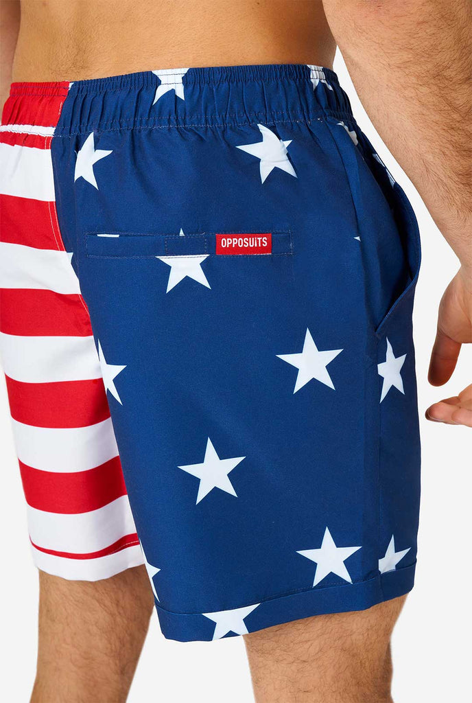 Mann, der Sommer -Outfit trägt, bestehend aus Hemd und Shorts, mit US -amerikanischen Flaggendruck, Shorts in der Nähe