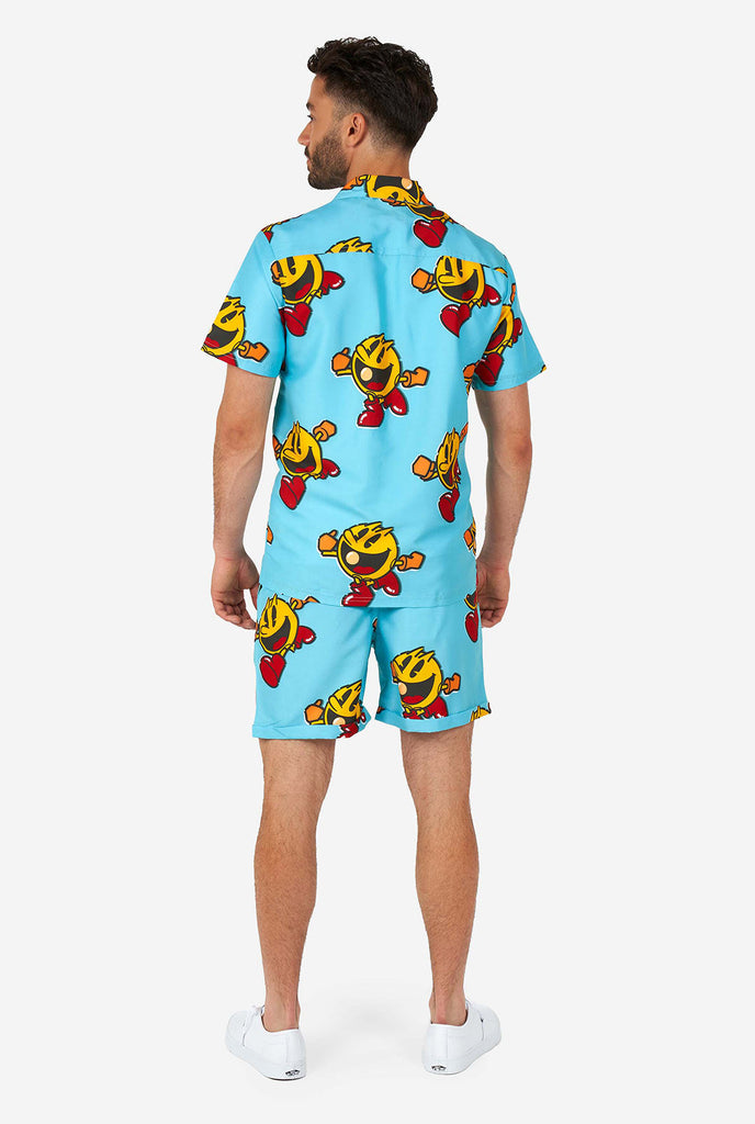 Mann trägt blaue Sommershorts und Hemd, mit Pac-Man-Druck, Blick von hinten