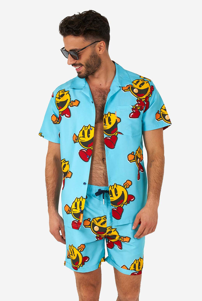 Mann, der blaue Sommershorts und Hemd mit Pac-Man-Druck trägt