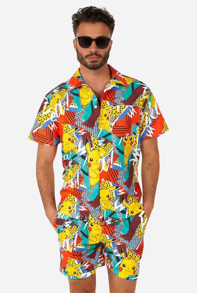 Mann, der bunte Sommershorts und Hemd mit Pikachu -Pokemon -Druck trägt