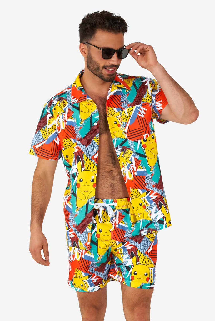 Mann, der bunte Sommershorts und Hemd mit Pikachu -Pokemon -Druck trägt