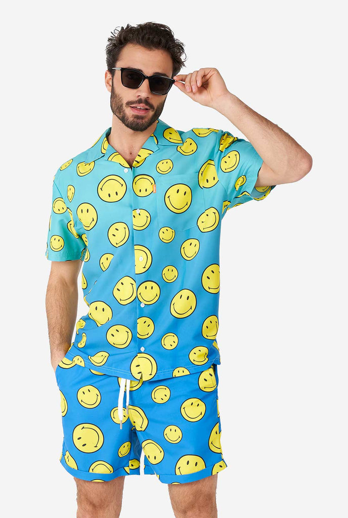 Mann, der blaues Sommerset trägt, bestehend aus Shorts und Hemd, mit Smiley -Druck