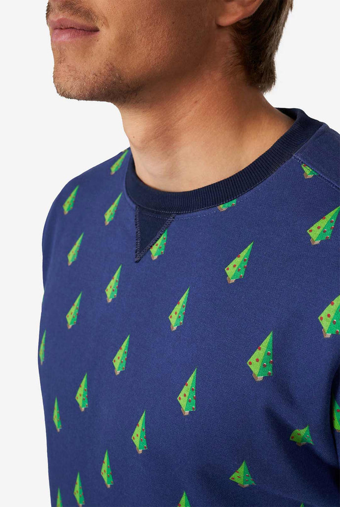Mann, der blauen Weihnachtspullover mit Weihnachtsbaumdruck trägt, Nahaufnahme
