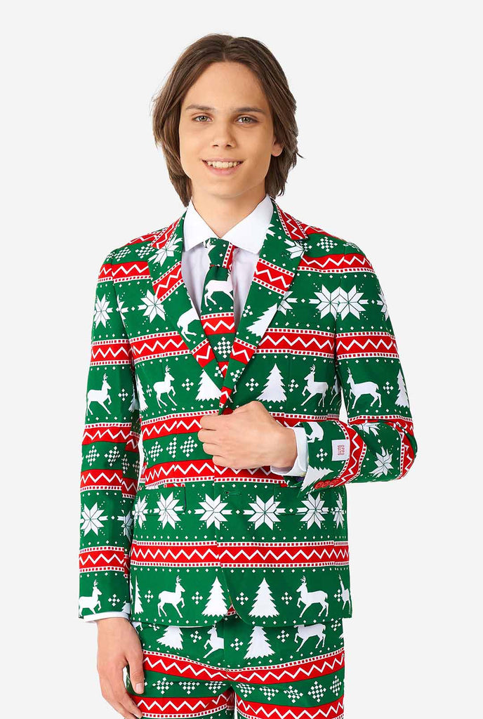 Teenager, der grüne formale Weihnachtsanzug trägt