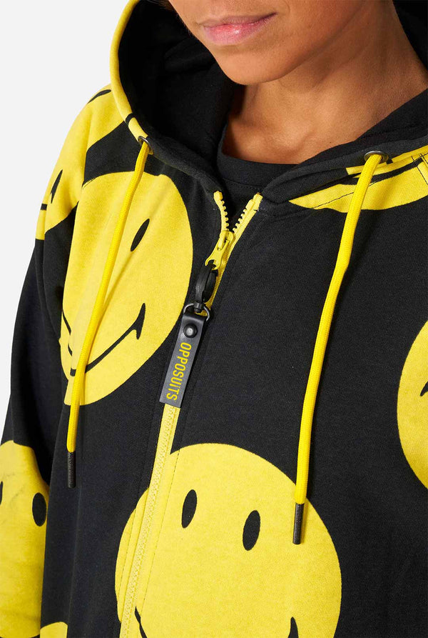 Frau trägt einen schwarzen Strampler mit gelbem Smiley, Brust in der Nähe