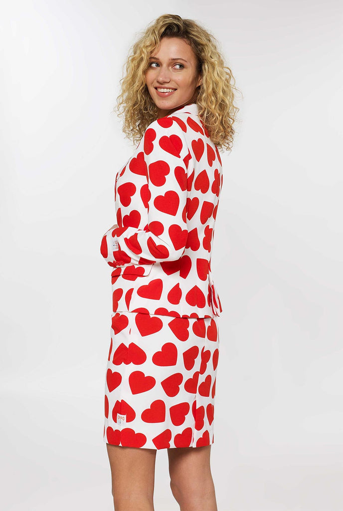 Frau, die weißen Valentinstagsanzug mit roten Herzen trägt, Blick von hinten