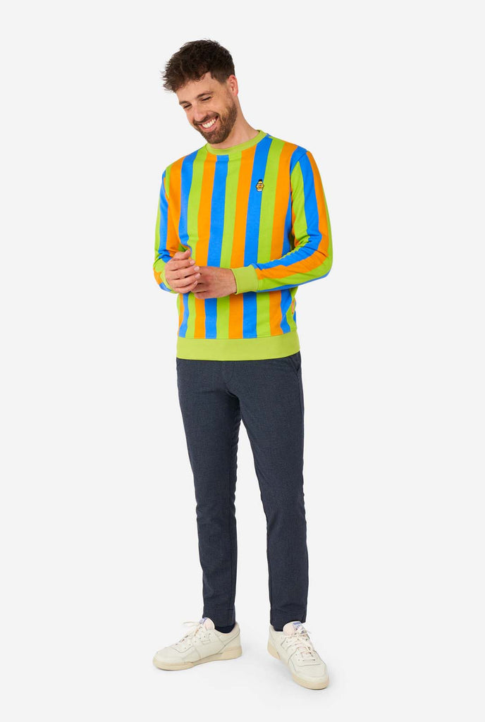 Mann trägt einen Herrenpullover im Sesamstraßen-Bert-Stil mit grünen, blauen und orangefarbenen Streifen